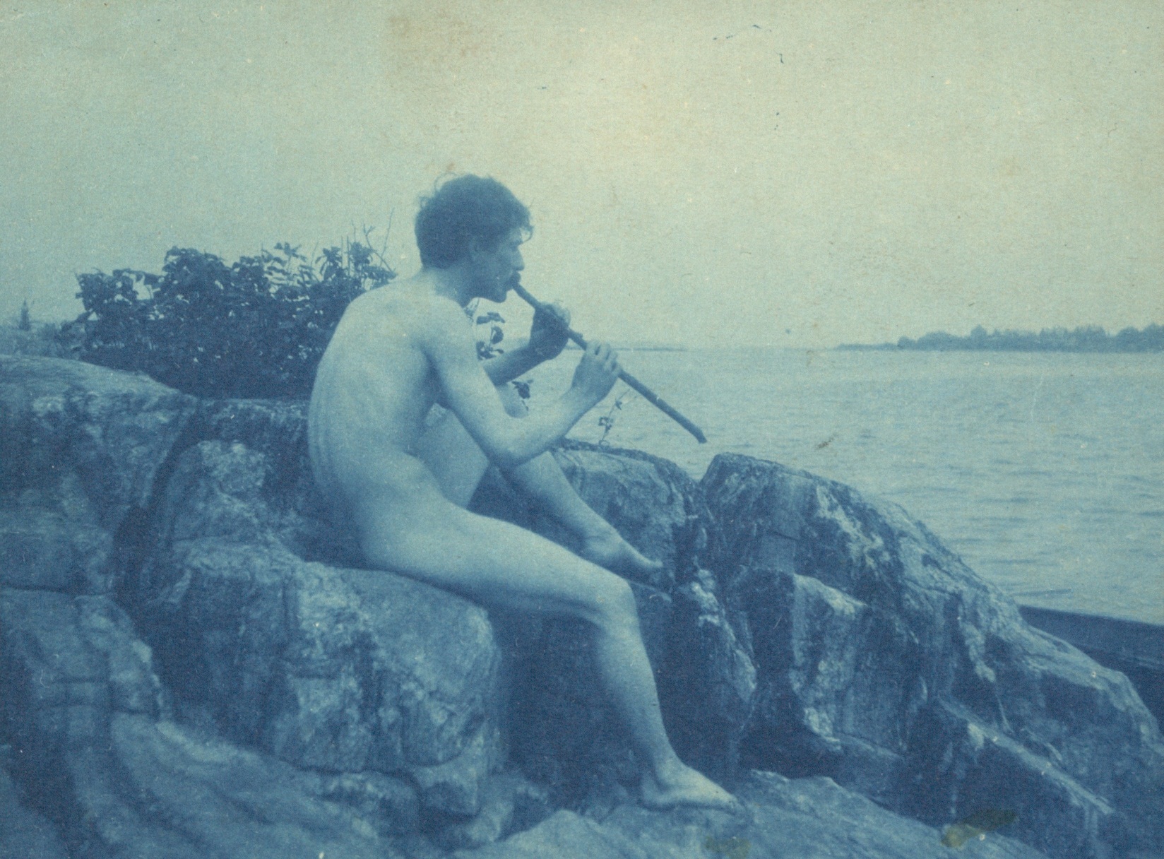 Man posed on rocks nude playing pipe Pan photograph by Frances Benjamin Johnston