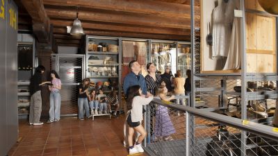 Besuchende im Museum Luzern am Objekte betrachten